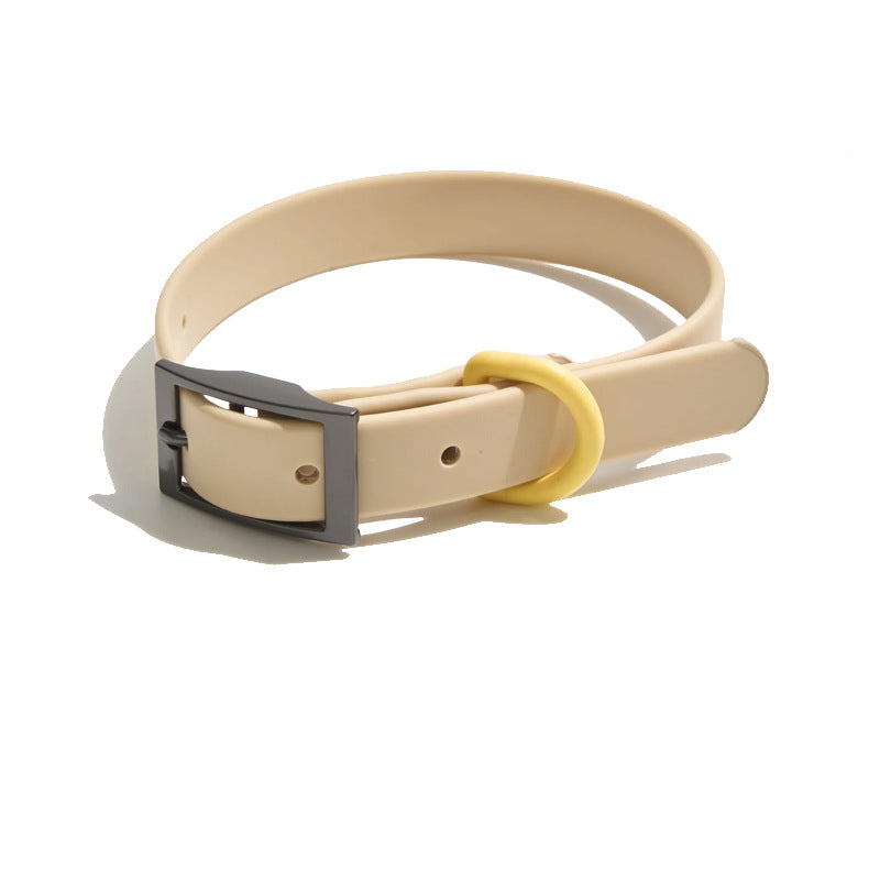 Tan PVC dog collar with gunmetal pin buckle and yellow keeper loop, plain background
