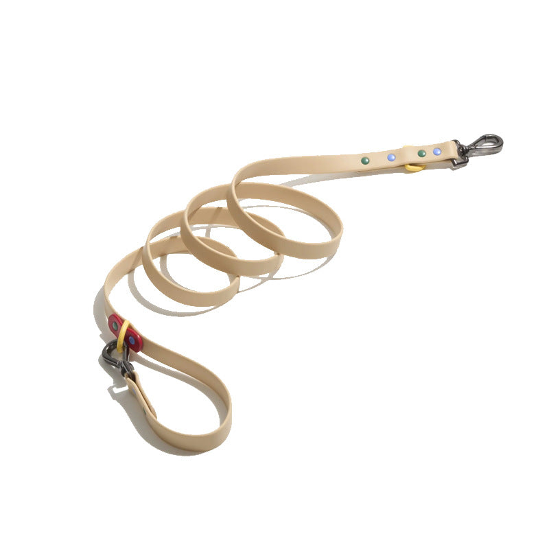 Tan PVC dog lead coiled, gunmetal trigger clip, coloured studs and handle loop