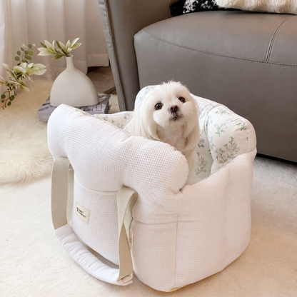 Small white dog in a white waffle-textured carrier with floral lining