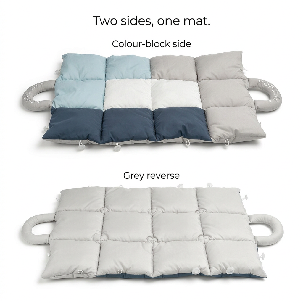 Quilted travel mat showing its blue, white, navy and grey colour-block side and plain grey reverse, both with padded handles.