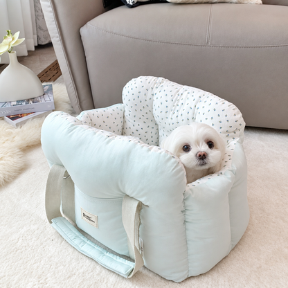 Small white dog in a pale mint carrier with floral lining